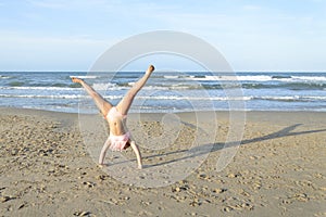 Girl doing cartwheel on the beach
