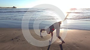 Girl Doing Cartwheels along Beach Shore