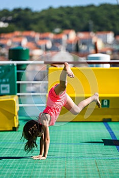 Girl doing cartwheels on Croatian ferryboat in Mali Losinj