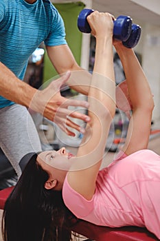 Girl doing chest flys with trainer help photo