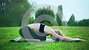 Girl doing child pose entry level yoga in park outdoor