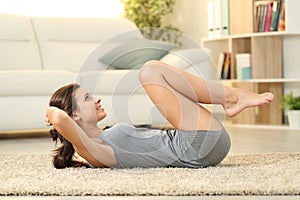 Girl doing crunches on a carpet at home