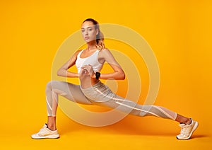 Girl Doing Deep Lunge Exercise Over Yellow Background