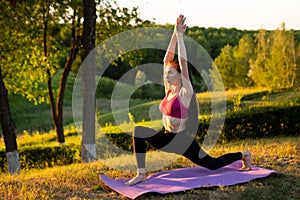 Girl is doing exercises in the morning on a background of nature