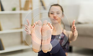 Girl doing fitness exercise for abs on floor, focus on feet
