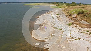 The girl is doing fitness on the lake shore