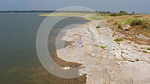 The girl is doing fitness on the lake shore