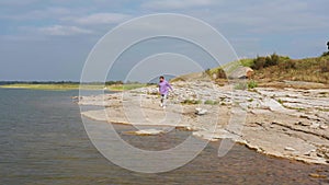 The girl is doing fitness on the lake shore