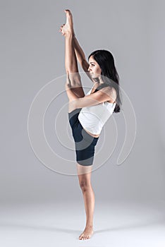 Girl doing gymnastic poses in studio