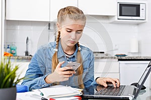 Girl doing her homework using smartphone