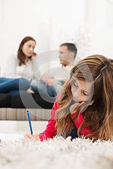 Girl Doing Homework Lying On Carpet