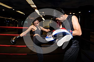 Girl doing kick exercise during kickboxing training with personal trainer