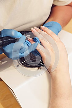 A girl is doing manicure. A girl is cutting nails photo