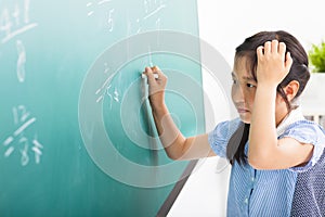 girl doing math problems on the chalkboard