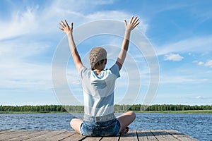 Girl doing morning exercises at the lake on a nice day