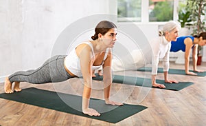 Girl doing Phalakasana asana during group yoga training