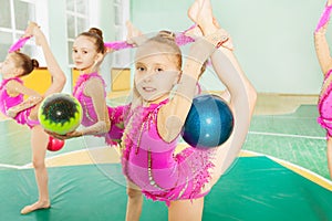 Girl doing rhythmic gymnastics elements with ball