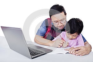 Girl doing school assignment with dad