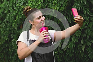 Girl doing selfie on a background of green plants