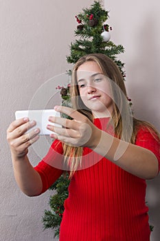 Girl doing selfie near New Year tree