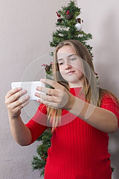 Girl doing selfie near New Year tree