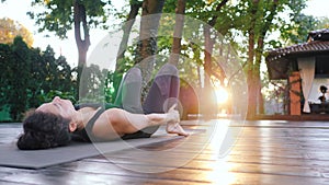 Girl doing Setu Bandha Sarvangasana, Bridge Pose. Young woman with oriental appearance practicing Kandharasana yoga