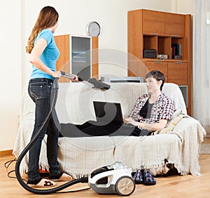 Girl doing sofa cleaning with vaccuum cleaner
