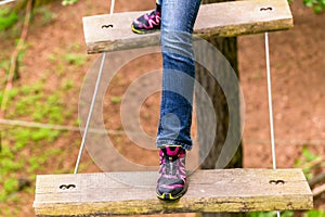 Girl doing step on rope bridge