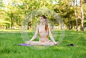 Girl doing stretching exercises outdoors. Young woman practicing yoga