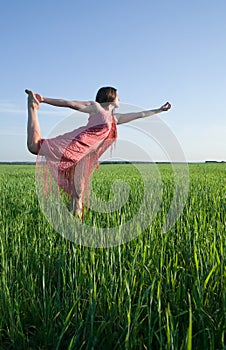 Girl doing yoga against nature during sunset