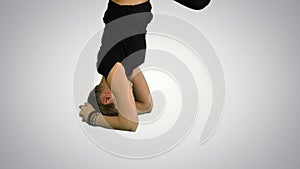 Girl doing yoga asana upavishtha konasana shirshasana, bound Angle Pose in head stand on white background