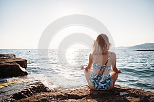 Girl doing yoga at beach, at sunset time. Healthy lifestyle