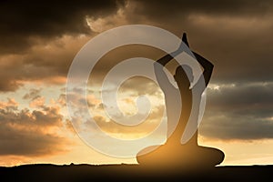 Girl doing yoga excercise at sunset.