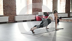 girl doing yoga exercises, standing in downward facing dog pose asana, bakasana