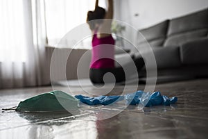 Girl doing yoga at home after breaking free from the protective mask and gloves from coronavirus, covid-19