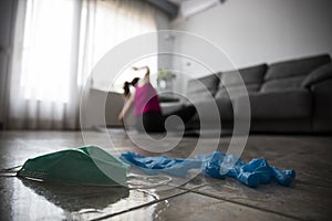 Girl doing yoga at home after breaking free from the protective mask and gloves from coronavirus, covid-19