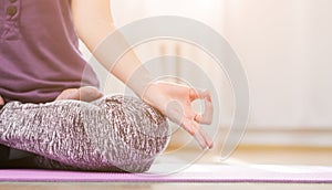 Girl doing yoga indoors in lotus asana