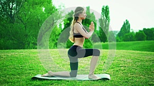 Girl doing yoga mist park. Morning kneeling salute sun pose