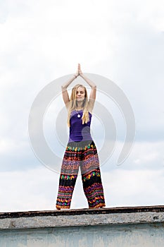 Girl doing yoga on the roof