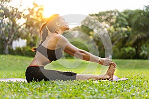 Girl doing yoga at sunset in Thailand in the park