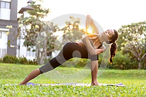 Girl doing yoga at sunset in Thailand in the park