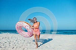 Girl with donut lilo on the beach