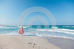 Girl with donut lilo on the beach