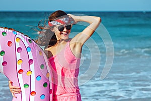 Girl with donut lilo on the beach