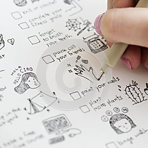 Girl doodling and making a checklist in a notebook photo