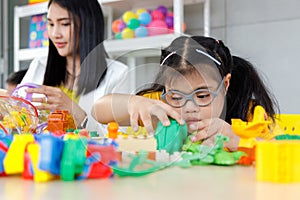 Girl with Down`s syndrome playing toys.