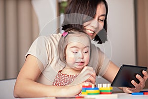 Girl with down syndrome and her mother are talking online via video call with her family, grandmother, remote congratulations