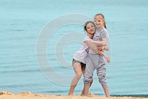 Girl with Down syndrome hugging her best friend on the beach