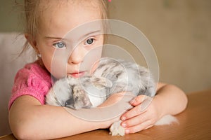 Girl with Down syndrome hugs the rabbit