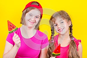 Girl Down syndrome and little girl with large Lollipop